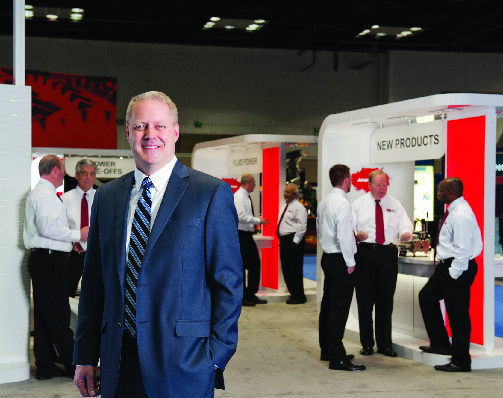 An image of Scott Huntsman at the Muncie Power trade show booth with members of the team behind him.